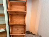 a tall wooden shelf next to a cabinet in a room