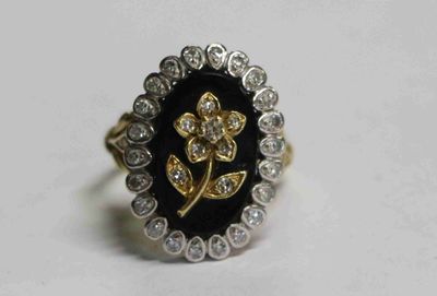 une image représentant une bague noire et dorée ornée d'une fleur