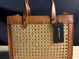 a brown and tan handbag with a tag on it
