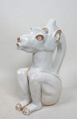 une sculpture en céramique blanche représentant un chien assis par terre