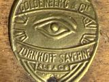 an old brass plate with an eye on it sitting on a table