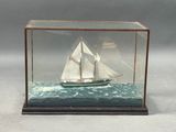 a glass case with a model of a sailboat in it