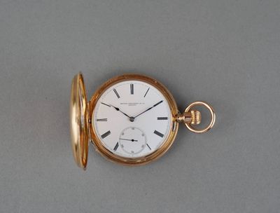 a gold pocket watch on a gray surface