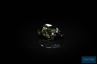 une tourmaline verte posée sur un fond noir