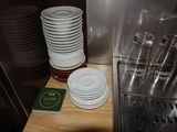 a stack of plates on a counter next to a sink