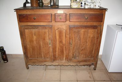 a wooden cabinet with two drawers and a small refrigerator in the corner