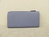 a small blue wallet sitting on top of a white couch