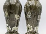two vases sitting side by side on a white surface