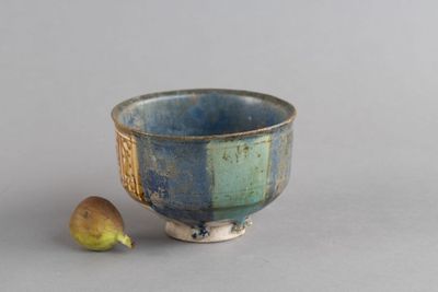 un bol bleu et vert avec une banane à côté