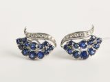 une paire de boucles d'oreilles en saphir et diamants sur fond blanc