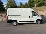 a white van parked in a parking lot near a stone wall