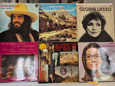 a lot of records on a table with a man in a yellow hat