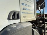 un camion sur le flanc duquel est apposée une pancarte
