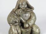 l'image d'une statue de femme assise sur un rocher