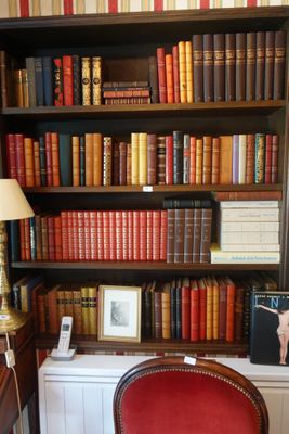 une chaise rouge devant une bibliothèque remplie de livres