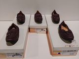 Quatre paires de chaussures sont exposées dans une vitrine