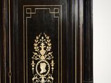 a black and gold armoire with a clock on it