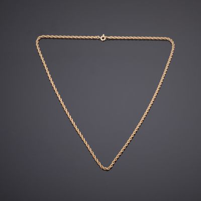 un collier en or avec une chaîne sur un fond sombre