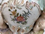 a vase with two cherensils on it and a cherenle on the bottom