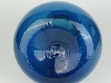 a close up of a blue glass ball on a white surface