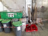 a pile of trash in a garage next to a red and white caution tape