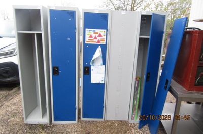 trois casiers bleus alignés les uns à côté des autres dans un parking