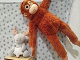 a stuffed monkey hanging on a wall next to a doll