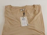 Le t-shirt est de couleur beige et comporte une étiquette.