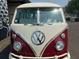 un minibus Volkswagen rouge et blanc garé sur un parking