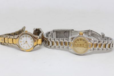 two ladies ' s wrist watches are sitting side by side on a white surface