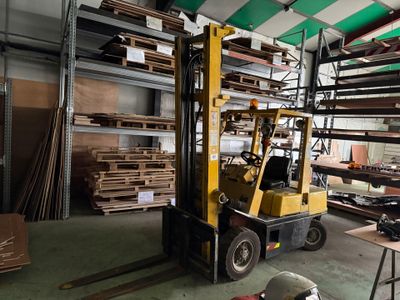 un chariot élévateur dans un entrepôt rempli de bois