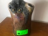 a small vase with an owl on it sitting on a table