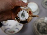 a person that is holding a tea cup and saucer