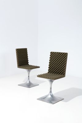 une paire de chaises modernes dans une pièce blanche avec un mur blanc