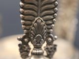 a close up of a metal object with a leaf on it