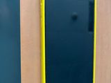 un téléphone portable noir et jaune accroché à un mur en bois