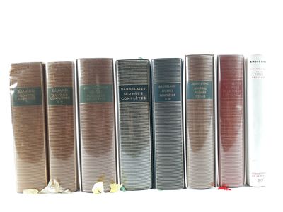 several books are lined up in a row on a white surface
