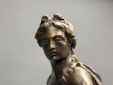 bronze statue of a woman holding a flower in her hand