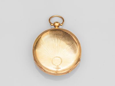 gros plan d'une montre de poche en or sur une surface blanche