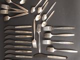 many forks and spoons arranged on a black surface