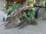 a tractor that is sitting on the ground next to a pile of machinery