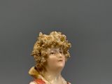 une figurine représentant une femme vêtue d'une robe rouge et blanche