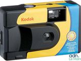 un appareil photo Kodak jaune et noir posé sur une boîte bleue et jaune