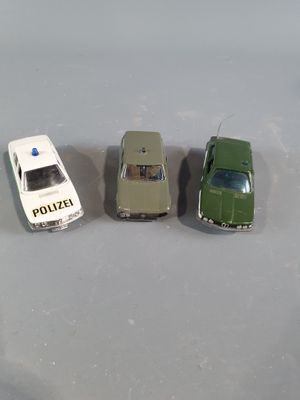 three toy cars sitting next to each other on a table