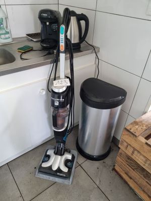 un aspirateur posé par terre dans la cuisine