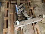 une photo montrant une pile de palettes en bois et une perceuse