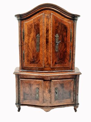 une vieille commode en bois à deux tiroirs, surmontée d'une horloge