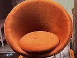 une chaise orange et une chaise marron dans un salon