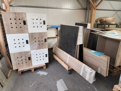 plusieurs pièces de bois sont empilées sur des palettes dans un entrepôt