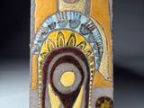carreau de céramique jaune et marron sur lequel est représenté le visage d'une femme